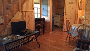 Ein gemütliches Blockhaus-Interieur mit Essbereich, Küche und einer Treppe.