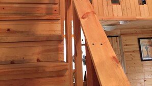Eine Holztreppe mit gewölbter Decke und einem Deckenventilator.