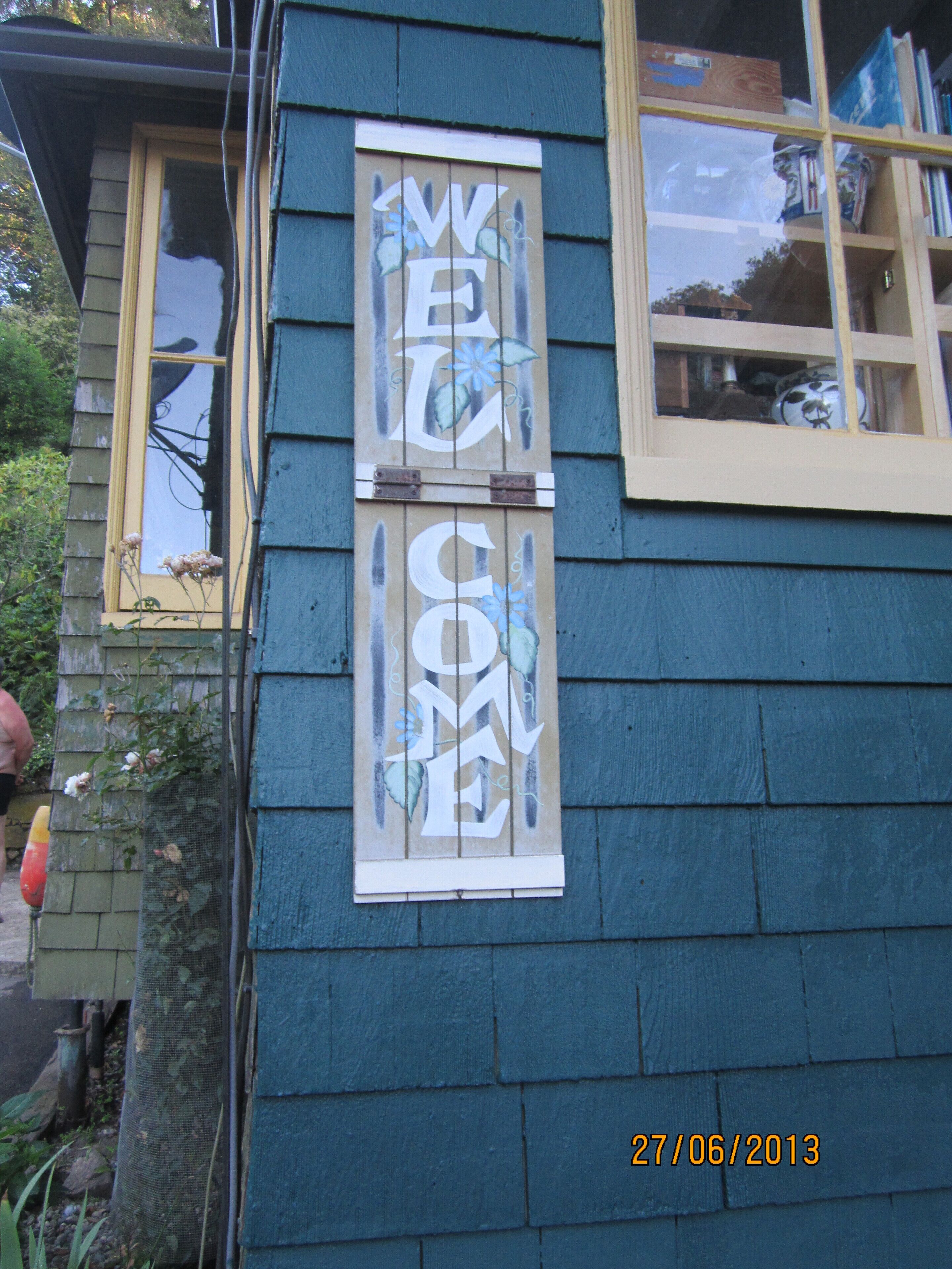 A house with a 'WELCOME' sign on the side.