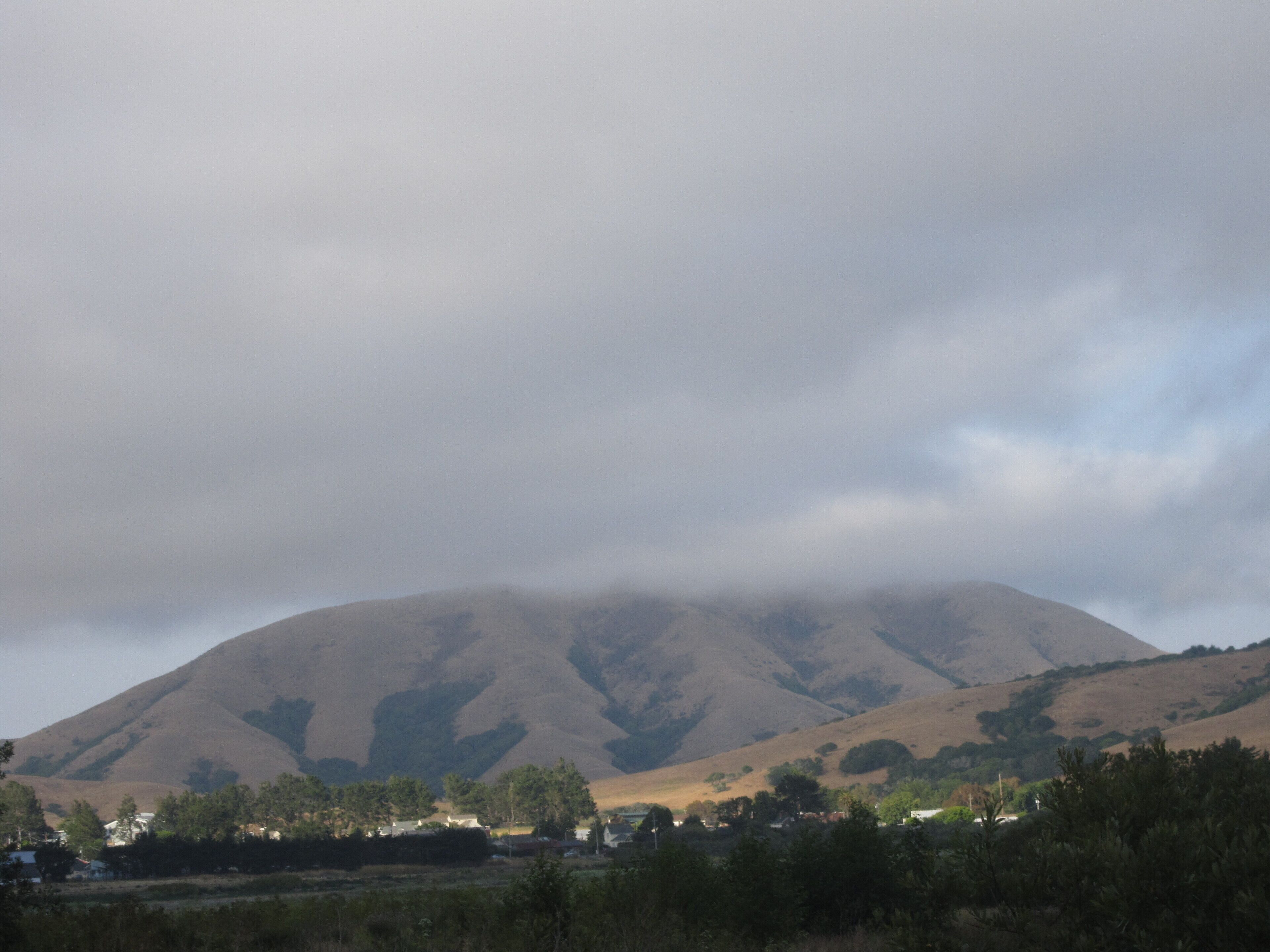 A mountain with a valley in the foreground.