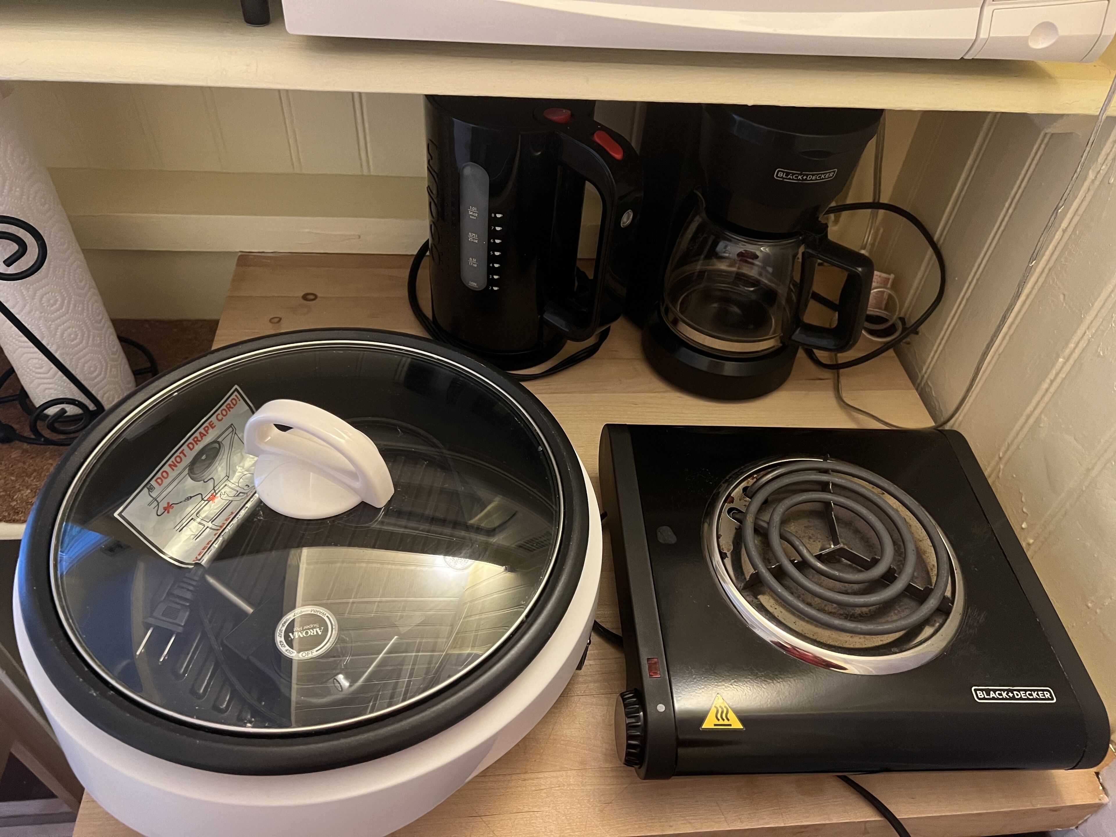 Eine Küche mit einer Mikrowelle, einer Kaffeemaschine und einem Reiskocher.