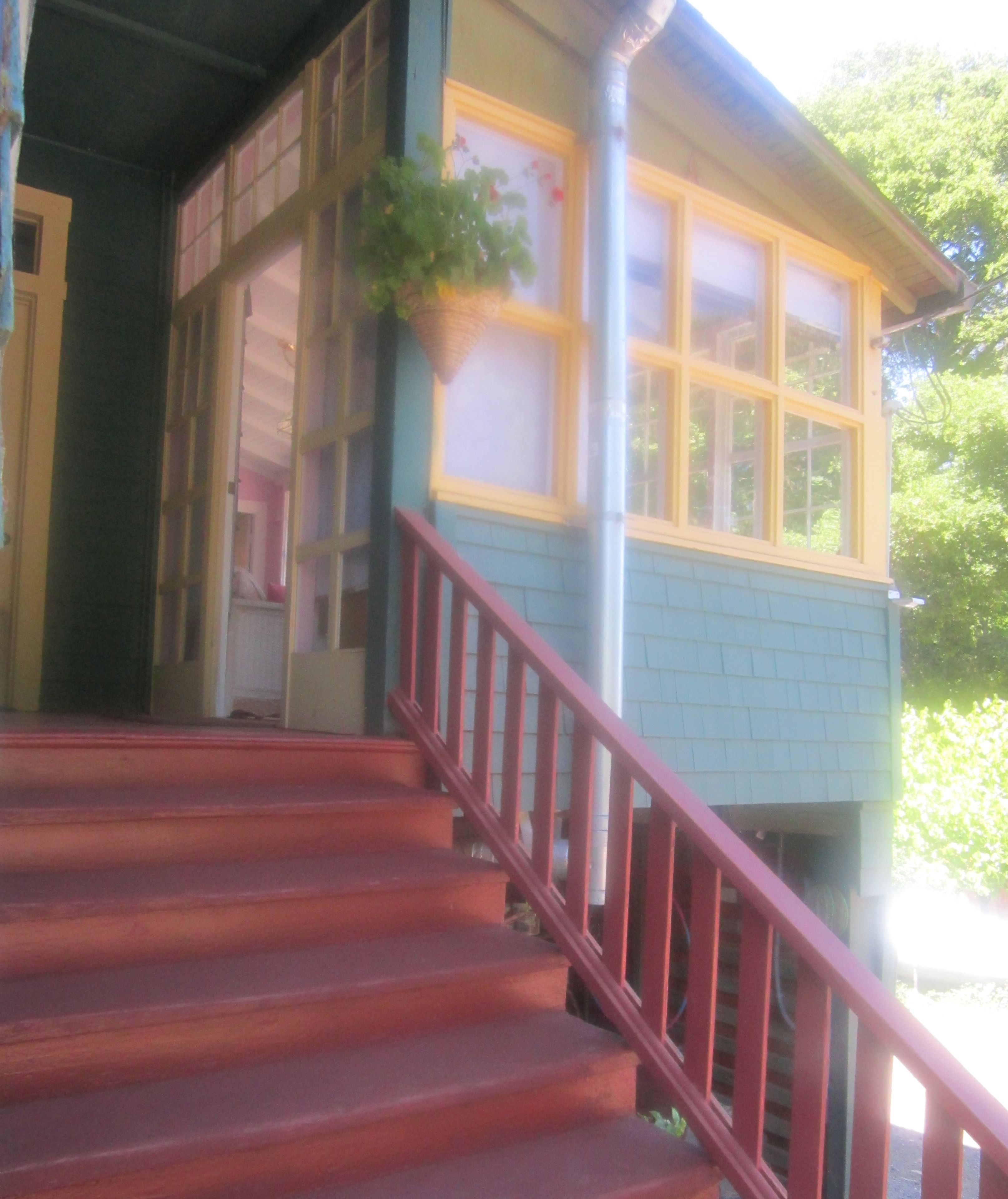 A staircase leading to a house with a red railing.