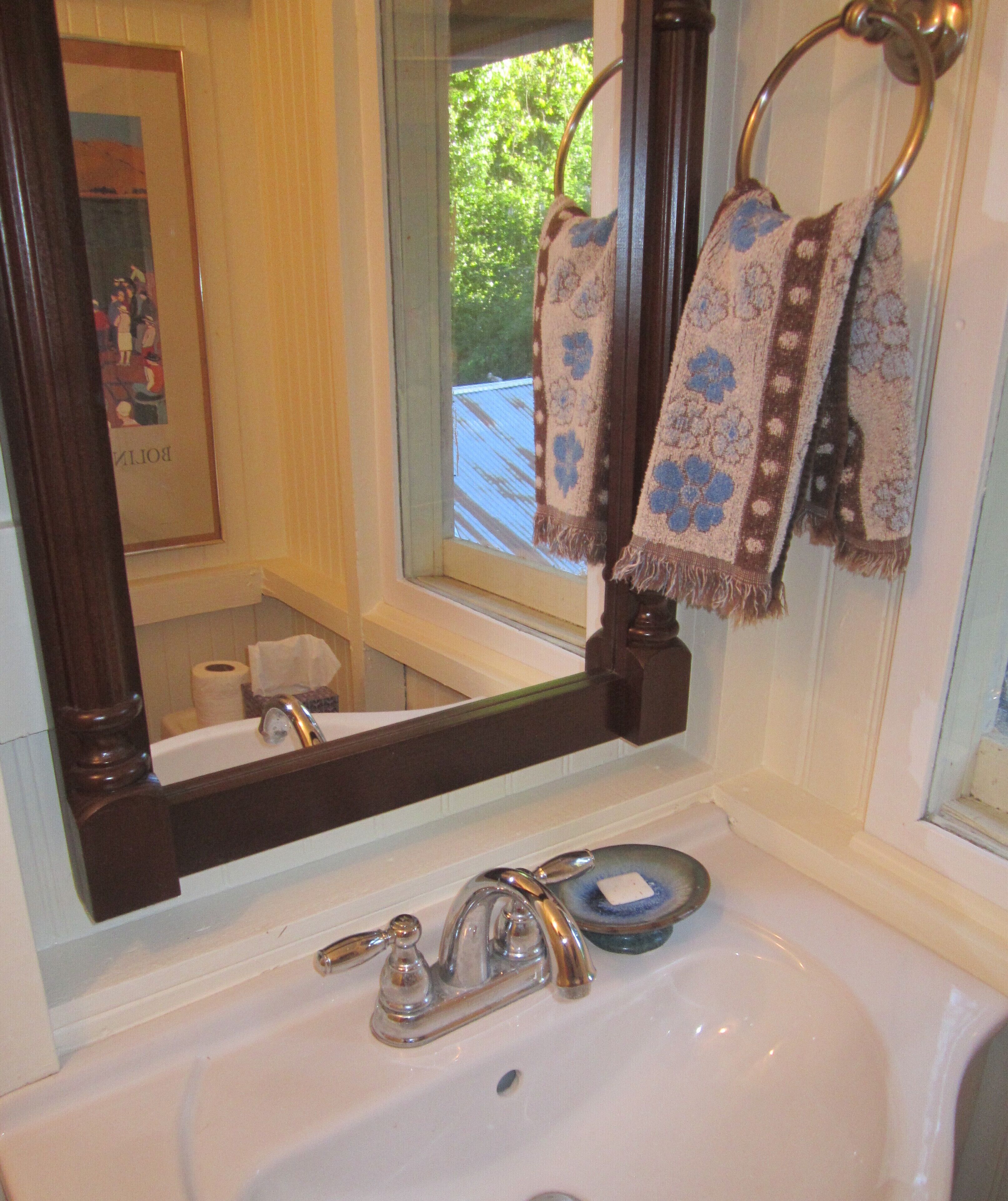 A bathroom with a sink, mirror, and towel rack.