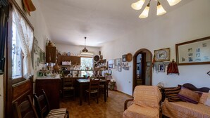 Una sala de estar acogedora y bien iluminada, con comedor, muebles de madera y diversos adornos.