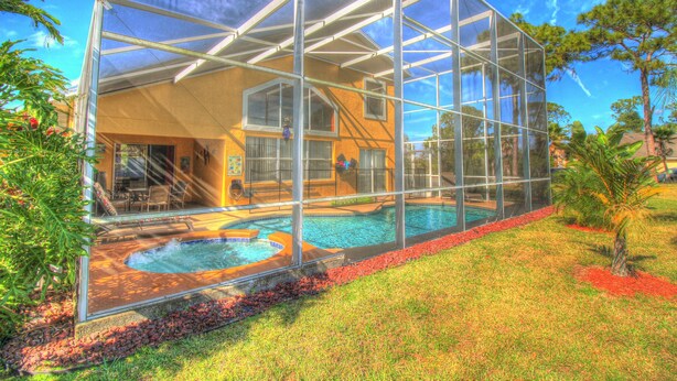 A house with a glass-enclosed patio and a swimming pool. - Adventure Villa - Heated Pool & Spa - Themed Rooms - Min. to Disney - Game room (Davenport)