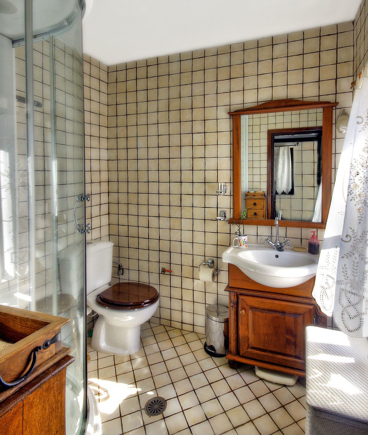 A bathroom with a toilet, sink, and mirror.
