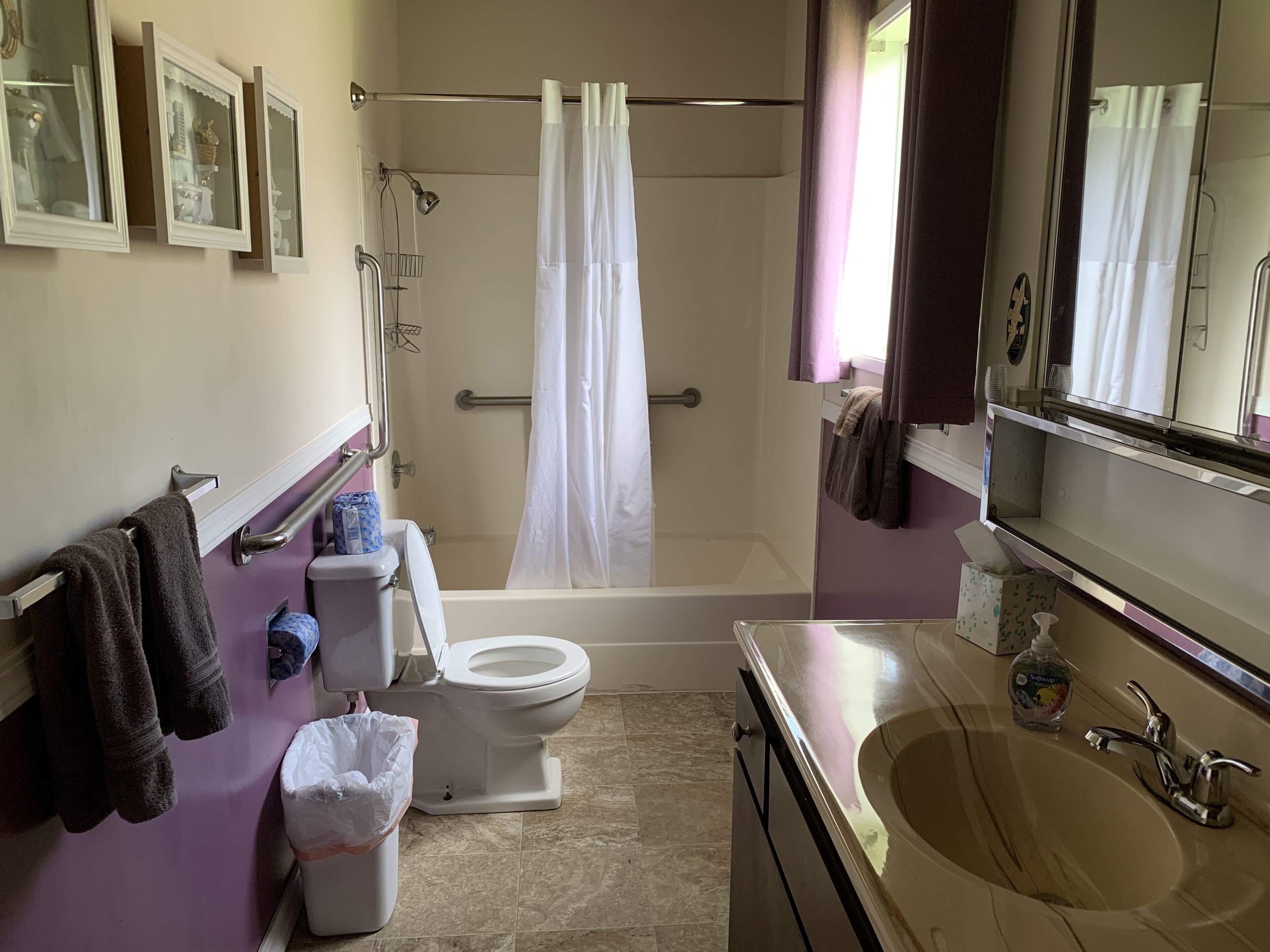 A bathroom with a toilet, sink, bathtub, and shower curtain.