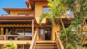 A two-story building with a wooden staircase leading to a door marked 'Welcome'.