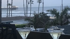 A view of the ocean with palm trees and a pier in the background. - North Coast A101 Corner condo West & South Facing Ocean views from Two Balconies (Oceanside)