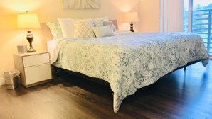 Une chambre à coucher avec un lit, des tables de chevet, une lampe et une fenêtre.
