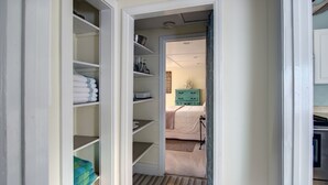 Habitación de hotel con vestidor, cama, cómoda y una pequeña cocina.