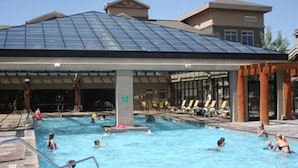 Une piscine dotée d’un toit abrité, de chaises longues et d’un espace aménagé au bord du bassin.