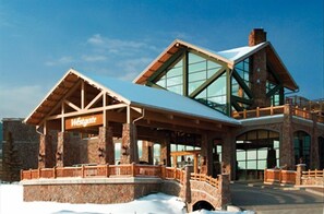 Westgate Lodge features a striking entrance with a large overhang supported by pillars and a glass facade.