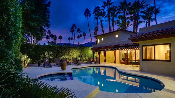 A pool area with a house, palm trees, and a mountain in the background. -  MOROCCAN POOL/SPA VILLA IN PALM SPRINGS GREAT DEEPWELL NEIGHBORHOOD
  PS ID106 (Palm Springs)