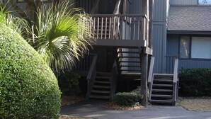 A two-story building with a wooden deck and a staircase leading to a second-floor balcony. - Gorgeous Fairway Oaks Villa, 100 yards from the beach (Kiawah)