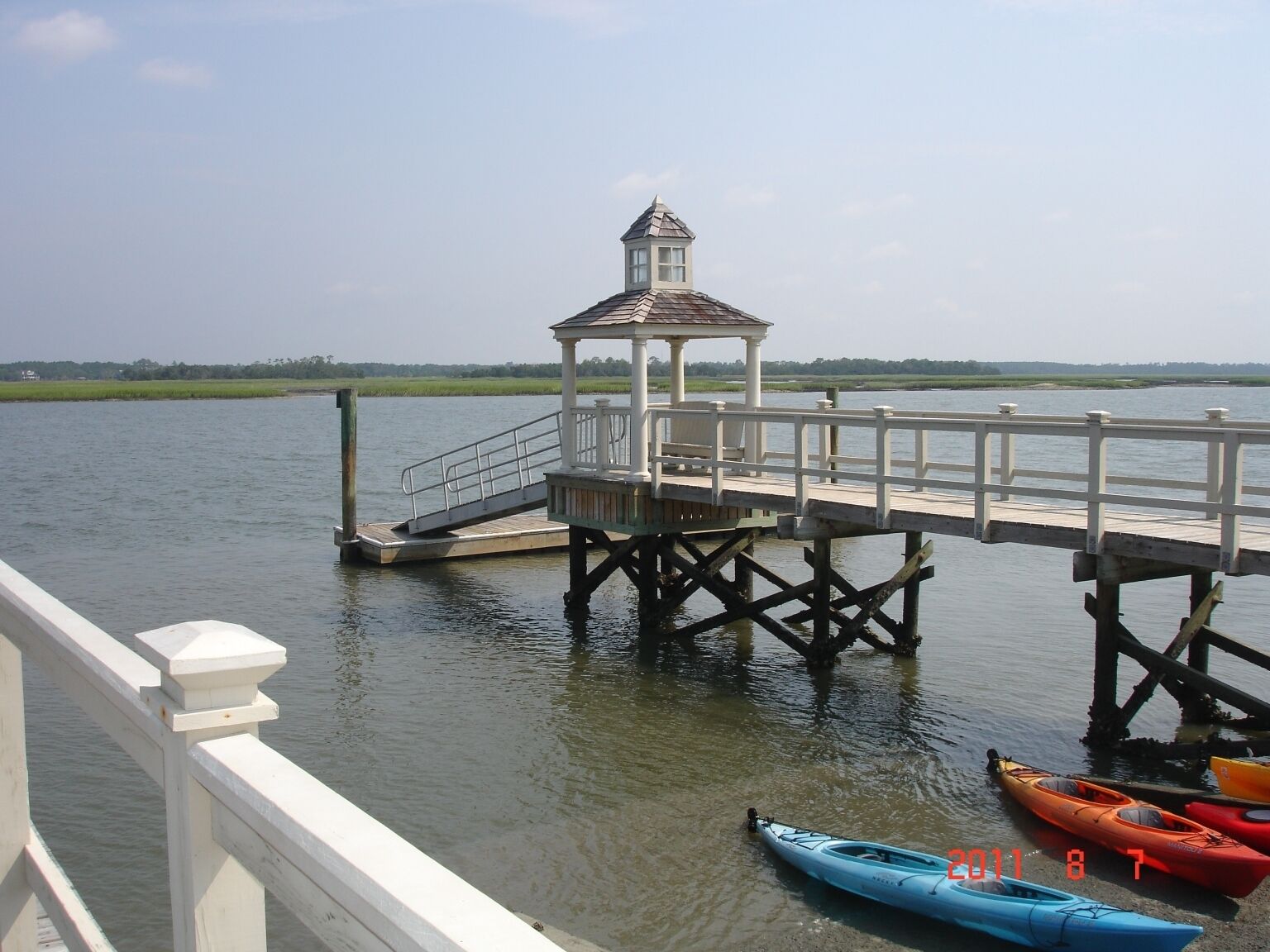 Un molo con un gazebo e kayak ormeggiati in fondo.