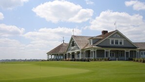 A large, two-story building with a covered porch and a well-maintained lawn in front. - Gorgeous Fairway Oaks Villa, 100 yards from the beach (Kiawah)
