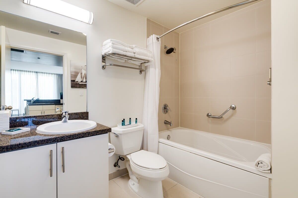 Een moderne badkamer met een bad, toilet en wastafel.