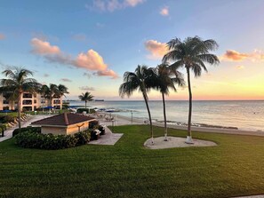 Un complexe hôtelier avec vue sur la plage, des palmiers et un bâtiment doté de balcons.