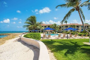 Ein Resort mit Poolbereich, Liegestühlen und Strand.