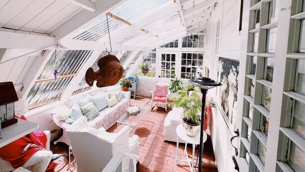 A spacious, well-lit room with a high ceiling, large windows, and a cozy seating area with a sofa and chairs. - Authentic 1795 Historic Homestead w/ Private Grounds for Gatherings and Retreats (Old Saybrook)