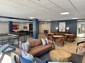 A modern lobby with a brown leather sofa, blue armchairs, and a wooden coffee table. - Luxury Bright Haus Villa True Ski in Ski Out Peak 9 Gorgeous Ski Area Views! (Breckenridge)