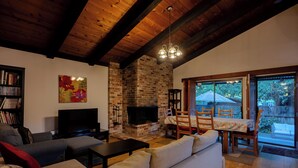 A living room with a brick fireplace, a television, and a sofa.