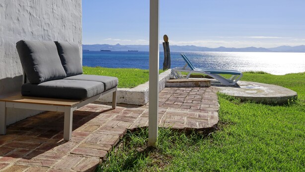 Une terrasse dotée d’un espace salon confortable et offrant une vue sur la mer.
