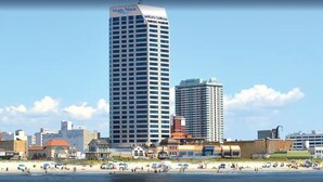 A high-rise hotel with a prominent "Atlantic Palace" sign, a beach with umbrellas, and a variety of buildings in the background. - DIRECT Oceanfront on Boardwalk — Thanksgiving — Nov 23-27 — 2, 3 or 4 nights (Atlantic City)