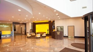 A hotel lobby with a reception desk, seating area, and a security desk. - DIRECT Oceanfront on Boardwalk — Thanksgiving — Nov 23-27 — 2, 3 or 4 nights (Atlantic City)