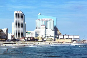 A coastal cityscape with prominent buildings including the Taj Mahal Hotel and Atlantic Palace.