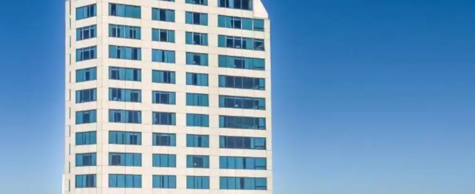 A tall, modern building with a grid of windows.