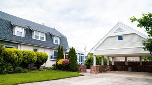 A residential driveway leading to a house with a covered garage.