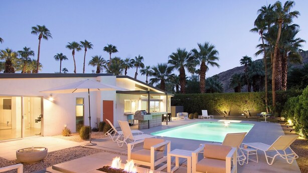 A modern house with a swimming pool, outdoor seating, and a fire feature. - Hollywood History Views Saltwater Pool & Spa (Palm Springs)