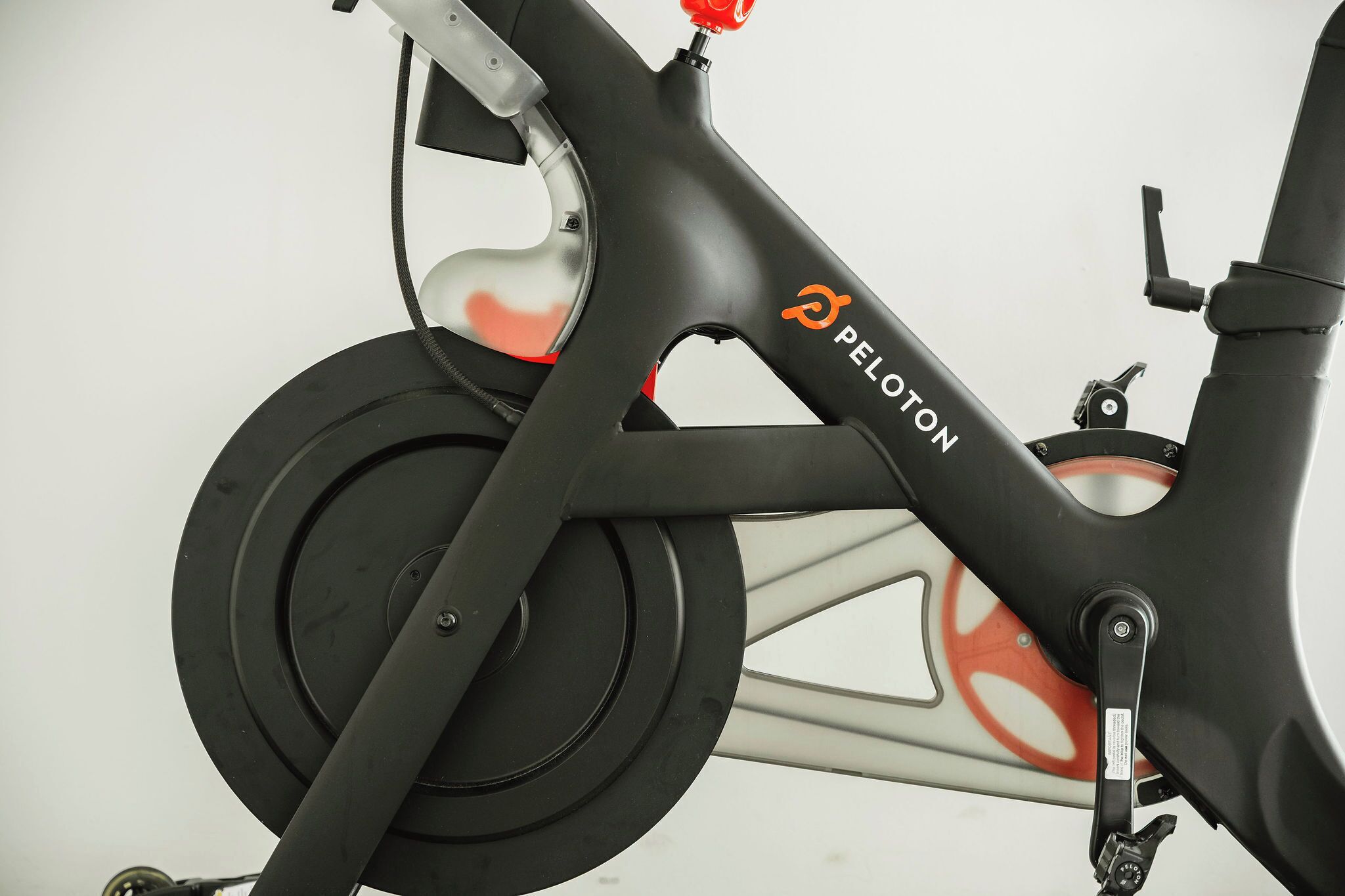 A stationary bike with the brand name "Peloton" visible on the frame.