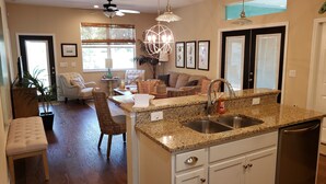 A modern kitchen with granite countertops, a double sink, and a built-in dishwasher.