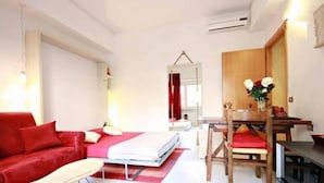 A modern bedroom with a red sofa, a bed, a dining table with chairs, and a mirror. - ❤Lovely Studio Near Trastevere Jacuzzi, WiFi, Aircon, patio Fully furn Kitchen (Rome)