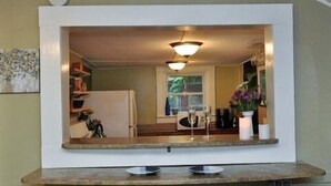 A kitchen with a built-in counter, a refrigerator, and a window. - Sweet Cabin in the Woods -10 min to Ashvl., Quiet, BEES , Garden & DECK. Dogs Ok (Asheville)