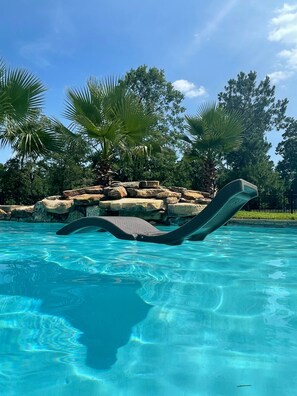 A clear blue pool with a floating lounge chair. - Prancing Horse Estates~Private, gated 10 acre retreat with pool, spa, waterfall (Montgomery)