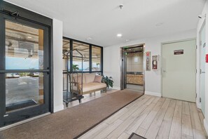 A hotel lobby with a reception desk, a seating area with a sofa, and an elevator. - Special Rates for Dec 05-26, 2026 - All Rooms Directly Beach Front (Madeira Beach)