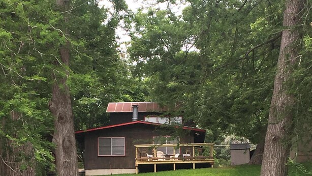 Une propriété privée comprenant une maison, une terrasse et un étang.