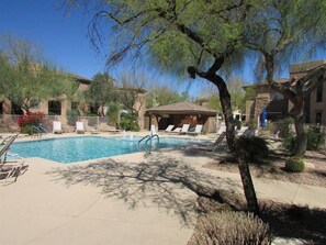 A pool area with lounge chairs and a small pavilion. - plush gated condo with heated pool, near westworld (Scottsdale)