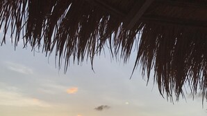 A beach scene with a sunset, boats on the water, and two people walking along the shore. - Ti Zan: Views to Die For. Perfect for two (Gros Islet)