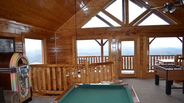 A wooden room with a pool table, foosball table, and jukebox. - Couples Dream Getaway! Unobstructed Views of the Smoky Mountains National Park! (Sevierville)