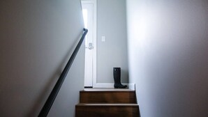 Una escalera de madera que lleva a una puerta blanca.