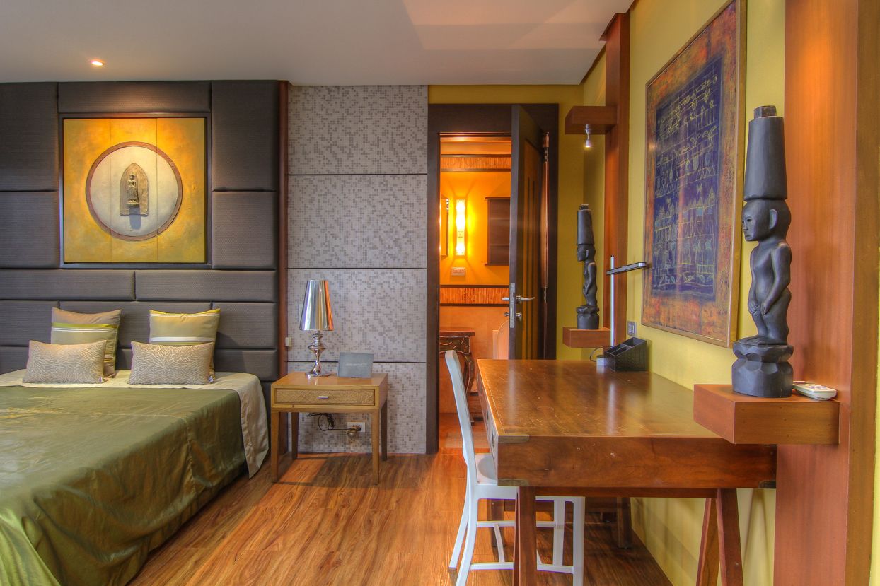 A hotel room with a bed, bedside table, and a dining table.