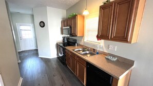 A kitchen with wooden cabinets, a dishwasher, a microwave, and a stove.