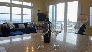 Una habitación con una mesa de comedor, dos copas de vino y una botella.