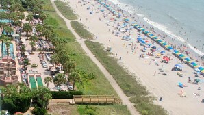 An aerial view of a beach resort with a long stretch of beach, a pool area, and a boardwalk. - 💎ISLAND TIME Dolphin Shack; Gorgeous Direct Oceanfront Balcony King Luxury Bed (Myrtle Beach)