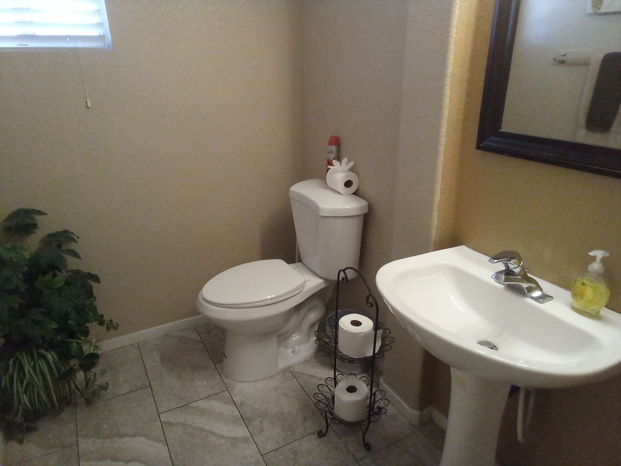 Ein Badezimmer mit Toilette, Waschbecken und Toilettenpapierhalter mit Papieren.
